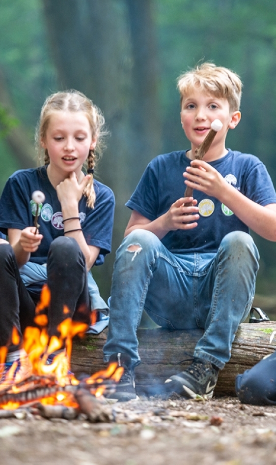 Children toasting marshmallows around a fire at Great Walstead